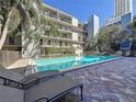 Relaxing community pool area with lounge chairs and a beautiful building in the background at 105 4Th Ne Ave # 501, St Petersburg, FL 33701