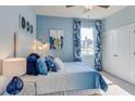 Cozy blue bedroom offering a comfortable bed, ample natural light, and a spacious closet for storage at 10523 Farm Hill Ave, Land O Lakes, FL 34638