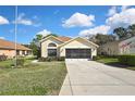 Inviting single-story home features lush green lawn and a large screened two-car garage at 11321 Copley Ct, Spring Hill, FL 34609