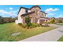 Charming two-story home with a stone facade, manicured lawn and a three-car garage at 13103 Wildflower Meadow Dr, Riverview, FL 33579