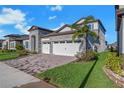Charming home with manicured lawn, stone accents, three-car garage, and driveway at 14522 Woodland Spur Dr, Lithia, FL 33547
