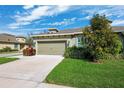 Charming single-story home featuring a two-car garage and manicured lawn at 1467 Twin Villas Way, Dunedin, FL 34698