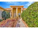 Home with covered entry, decorative plants, and brick paver walkway at 16232 Amethyst Key Dr, Wimauma, FL 33598