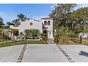 Inviting two-story home with a red tile roof, white stucco exterior, and lush tropical landscaping at 2227 29Th S St, St Petersburg, FL 33712