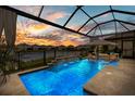 Gorgeous screened-in pool with a water feature, in-pool lounge chairs, and a serene view of the water at 3107 Mountain Spruce Ter, Wesley Chapel, FL 33543