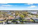 Stunning aerial view of waterfront property with private dock and boat lifts, surrounded by lush greenery and neighboring homes at 3598 10Th Ne St, St Petersburg, FL 33704