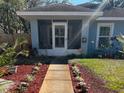 Charming home featuring a walkway to a screened porch entry and vibrant, landscaped front yard at 3850 6Th N Ave, St Petersburg, FL 33713