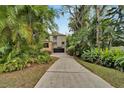 Long driveway leading to a meticulously landscaped home with lush greenery and stone accents at 4035 N River View Ave, Tampa, FL 33607