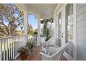Inviting front porch with brick floor, white wicker chairs, and lush potted plants at 5024 W Homer Ave, Tampa, FL 33629