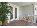 Relaxing side porch with brick floor, a swing, and French doors that lead into the home at 5024 W Homer Ave, Tampa, FL 33629