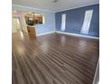 Open-concept living space with wood-look flooring and an adjacent kitchen view at 6194 59Th N Pl, St Petersburg, FL 33709