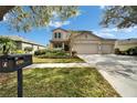 Charming two-story home featuring a spacious three car garage and a manicured lawn at 6308 Bridgevista Dr, Lithia, FL 33547