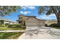 Charming two-story home with a three-car garage and well-maintained front yard at 6308 Bridgevista Dr, Lithia, FL 33547