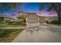 Lovely two-story home with a three-car garage at twilight at 6308 Bridgevista Dr, Lithia, FL 33547