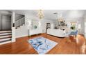 Bright living room featuring a staircase, hardwood floors, elegant chandelier, and comfortable seating area at 701 S Edison Ave, Tampa, FL 33606