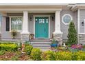 Close-up of a vibrant blue front door with white pillars, surrounded by lush landscaping and decorative accents at 7820 Marsh Pointe Dr, Tampa, FL 33635
