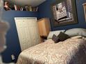Cozy bedroom featuring blue walls, carpet, and closet storage space at 8214 Tabbystone Pl, Bradenton, FL 34201