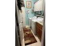 Functional laundry room with washer, dryer, storage cabinets, and a utility sink at 8214 Tabbystone Pl, Bradenton, FL 34201