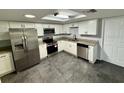 Modern kitchen featuring stainless steel appliances, white cabinetry and granite countertops at 8708 Robilina Rd, Port Richey, FL 34668