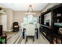 Open dining area offering wood-look flooring and a decorative light fixture at 9211 Seeger Ln, Land O Lakes, FL 34638