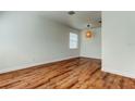Spacious room featuring hardwood floors, neutral walls, a window with blinds, and a pendant light fixture at 9407 Black Thorn Loop, Land O Lakes, FL 34638