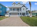 Charming two-story coastal home with a brick driveway, large garage, and a welcoming front porch at 112 79Th St # B, Holmes Beach, FL 34217