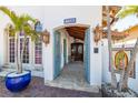 Inviting entryway with arched doorway, open blue doors, stone floors, and decorative outdoor lanterns at 11320 E 6Th E St, Treasure Island, FL 33706