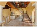 Grand foyer with tiled floors, stairs with iron railing, a balcony, and high ceilings with chandelier at 11320 E 6Th E St, Treasure Island, FL 33706