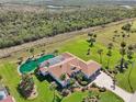 Stunning aerial view of estate with a private pool, screened lanai, and expansive lush green landscaping at 1145 Boundary Blvd, Rotonda West, FL 33947