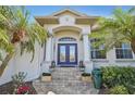 Elegant home entrance featuring a double door entry, stone steps, and decorative planters at 1145 Boundary Blvd, Rotonda West, FL 33947