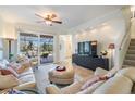 Cozy living room with plush seating, a ceiling fan, and sliding doors to the patio at 13247 Palmilla Cir, Dade City, FL 33525