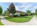 Lush green lawn surrounds this well-maintained home featuring mature trees and manicured bushes at 14315 Rolling Dune Rd, Lithia, FL 33547