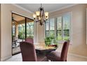 Cozy dining area with a chandelier, plantation shutters, and sliding glass doors to the lanai at 144 Silver Falls, Apollo Beach, FL 33572