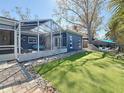 Spacious backyard showcasing the screened lanai, stone perimeter, and well-maintained artificial turf at 1859 Oklahoma Ne Ave, St Petersburg, FL 33703