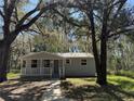 Quaint single story home with mature trees and a pathway leading to the entrance at 203 D Street, Brooksville, FL 34601