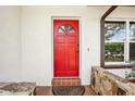 Inviting front entrance featuring a vibrant red door and decorative stonework at 2213 Spanish Vistas Dr, Dunedin, FL 34698