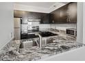 This kitchen features granite countertops with a stainless steel sink and faucet at 2333 Feather Sound Dr # A204, Clearwater, FL 33762