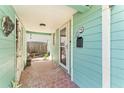 Covered front porch with a brick floor, siding, mailbox, and door at 300 16Th Ave, Indian Rocks Beach, FL 33785