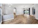 Light-filled living room featuring wood floors, neutral walls, an elegant chandelier, and an arched doorway at 3206 Hurley Grove Way, Valrico, FL 33596