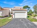 Exterior view of the home featuring a two car garage, landscaping, and manicured lawn at 4312 Sunray Ct # 36, Tampa, FL 33615