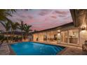 A luxurious outdoor pool and covered patio with dining and lounge area, perfect for entertaining at 4959 58Th S Ave, St Petersburg, FL 33715