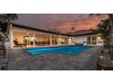 A stunning backyard pool surrounded by a patio, with an outdoor dining area, and a covered lounge space at 4959 58Th S Ave, St Petersburg, FL 33715