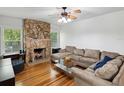 Cozy living room features a stone fireplace, hardwood floors, and neutral furnishings at 5604 N Cherokee Ave, Tampa, FL 33604