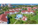 Scenic aerial view showcases the community pool and clubhouse, surrounded by lush landscaping and beautiful waterfront views at 6059 Bahia Del Mar Blvd # 134, St Petersburg, FL 33715