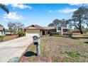 Front exterior showcasing a single-Gathering home with brick accents, a two-car garage, and a neatly kept yard at 8137 Greenside Ln, Hudson, FL 34667