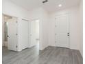 Bright hallway featuring doors, light gray flooring, and white paint at 9510 Xenia St, New Port Richey, FL 34654