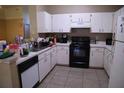 Functional kitchen with white cabinetry, black appliances, and tile flooring at 11019 Connacht Way, Tampa, FL 33610
