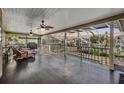 Spacious screened-in patio with ceiling fans, overlooking the water and lush scenery at 116 9Th E St, Tierra Verde, FL 33715