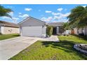 Beautiful single-story home featuring a manicured lawn, mature palm trees, and an attached garage at 1224 Cressford Pl, Brandon, FL 33511