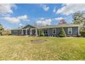 Inviting single-story home with a well-manicured lawn and symmetrical landscaping in front of the porch with stone supports at 12502 Lake Hills Dr, Riverview, FL 33569